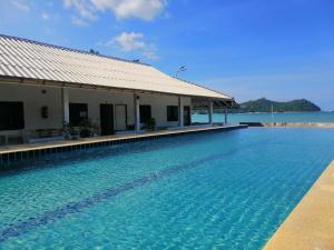 a swimming pool next to a building with the ocean in the background at Thong Nai Pan Beach Resort in Thong Nai Pan Yai