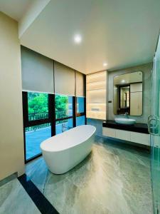 La grande salle de bains est pourvue d'une baignoire et d'un lavabo. dans l'établissement TAM ĐẢO GOLF VILLA 6 PHÒNG NGỦ, à Làng Hạ