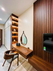 Làng HạにあるTAM ĐẢO GOLF VILLA 6 PHÒNG NGỦの鏡付きのデスク、テレビが備わる客室です。