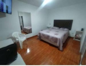 una camera con letto e pavimento in legno di Bello y acogedora casa -departamento habitaciones a Lima