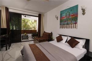 a bedroom with a bed and a large window at Forget Me Not Resort in Agonda