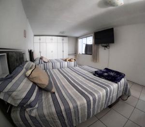 a bedroom with two beds and a flat screen tv at Departamento amplio y bonito en Arequipa 1er Piso in Arequipa