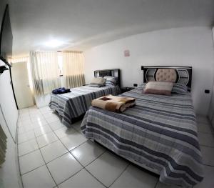 a bedroom with two beds and a tiled floor at Departamento amplio y bonito en Arequipa 1er Piso in Arequipa