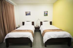 duas camas num quarto de hotel com lençóis brancos em SU 22 em Bangkok