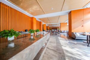 a lobby with a long counter with chairs and tables at Howard Johnson by Wyndham Lanting Hotel Ningbo in Ningbo