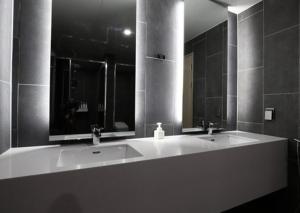 a bathroom with two sinks and a large mirror at H Avenue Hwamyeong in Busan