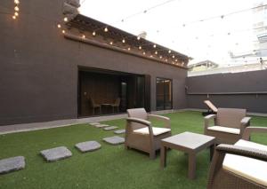 un patio avec des chaises et une cheminée dans un bâtiment dans l'établissement H Avenue Hwamyeong, à Busan