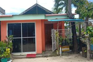 a small orange house with a large door at Cardo's Front Beach Room in General Luna +3 photos