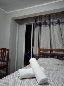 a bedroom with a bed with two white towels on it at Cardo's Front Beach Room in General Luna