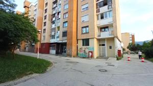 an empty street in front of a tall building at apartman dobrinja2 in Sarajevo