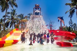 un grupo de personas en el agua en un parque acuático en PrideInn Paradise Beach Resort & Spa Mombasa, en Mombasa