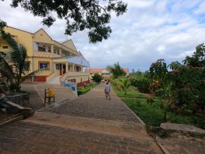a man walking down a brick road in front of a building at Centre Lucien Botovasoa in Diego Suarez +37 photos