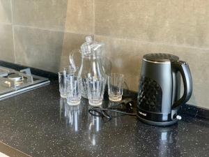 ekspres do kawy i szklanki na blacie kuchennym w obiekcie Medion Apartments w Taszkiencie