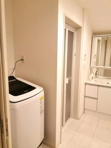 a kitchen with a washing machine in a room at Bell house in Tokyo