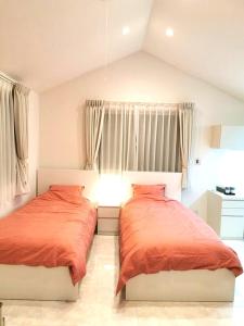 東京にあるBell houseのベッドルーム1室(オレンジのシーツを使用したベッド2台付)