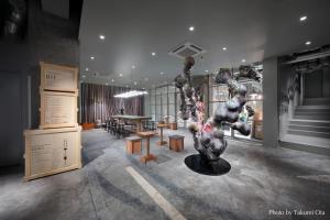 東京にあるKAIKA Tokyo by THE SHARE HOTELSのテーブルと彫刻が飾られた部屋