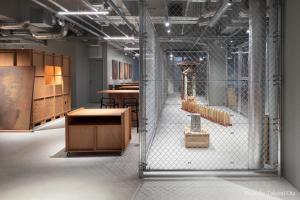 東京にあるKAIKA Tokyo by THE SHARE HOTELSの木製のテーブルと椅子が並ぶ建物内の部屋
