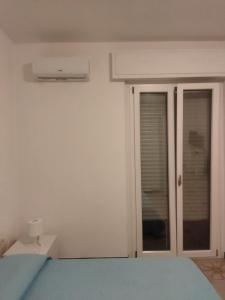 Schlafzimmer mit einem Bett und Glasschiebetüren in der Unterkunft Casa di Andy in Cagliari