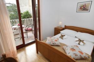 1 Schlafzimmer mit einem Bett und einem Balkon mit einem Tisch in der Unterkunft Apartment Marina - sea view in Trogir