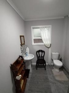a bathroom with a sink and a toilet and a window at Coastal Cottage in Klein Brak Rivier
