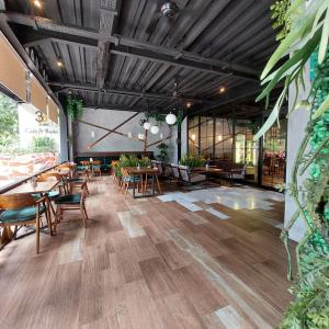 een restaurant met houten tafels, stoelen en planten bij 3 Point Syariah Residence in Jakarta