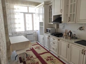 een keuken met witte kasten, een wastafel en een raam bij Prestigious apartment in Bishkek in Bisjkek