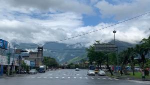 a street with cars driving down a street with a mountain at KID Hualien Hostel in Hualien City