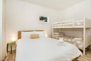 1 dormitorio con 1 cama y 1 litera en Claras Coastal Cottage Pet Friendly 1 Min Walk to Beach en Currarong