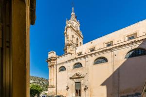 budynek z wieżą zegarową na górze w obiekcie Casa del Duomo Modica w mieście Modica