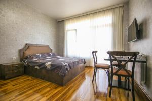 a bedroom with a bed and a desk and a chair at Hotel "GrapeHill" in Ts'ikhisdziri +18 photos