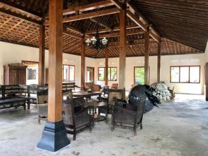 a dining room with tables and chairs in a building at Ohmmstay - Rumah Pendopo in Tanjungtirto