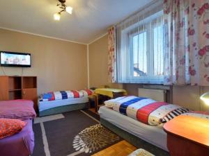 a room with two beds and a television in it at Noclegi16 in Bolesławiec