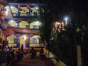 a group of people sitting outside of a building at night at PARVATI MANDREM in Mandrem