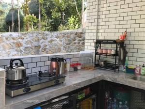 a kitchen with a stove top oven next to a sink at Dango1881muslim riverstay in Padang Rengas
