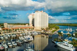 The Westin Cape Coral Resort at Marina Village في كيب كورال: مرسى فيه قوارب في الماء بجانب مبنى