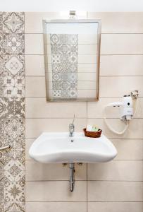 een witte wastafel in een badkamer met een spiegel bij Limnaio in Chrysohorafa