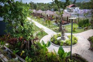 a garden with a statue in the middle of a park at Kampot Tropical Village in Kampot