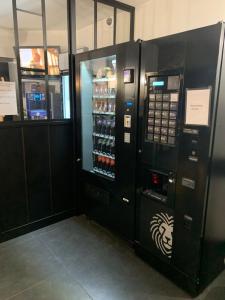 2 distributeurs automatiques dans un bâtiment avec des boissons dans l'établissement Hotel Macon la Salle, à Mâcon