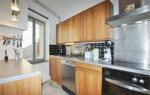 a kitchen with wooden cabinets and a stainless steel appliance at Beautiful Home In Villeseque Des Corbier With House A Panoramic View in Villesèque-des-Corbières