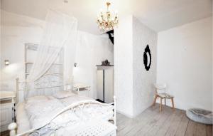una camera da letto bianca con un letto e un lampadario di Gorgeous Home In Villeseque Des Corbier a Villesèque-des-Corbières