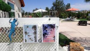 a fence with two posters and a blue lizard on it at MAGIC VILLA Overlooking Pool Oasis in Temecula