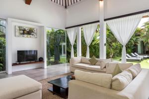 a living room with two couches and a tv at Villa Alice in Seminyak