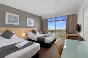 a hotel room with two beds and a balcony at Scamander Beach Resort in Scamander