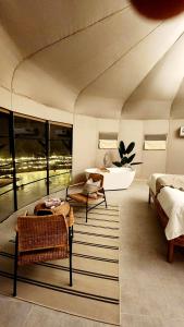 BadīyahにあるStarry Domes Desert Campのベッド、バスタブ、シンクが備わる客室です。