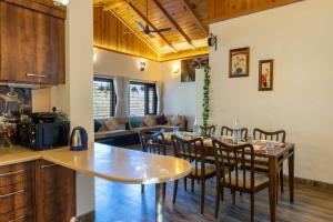 a kitchen and dining room with a table and chairs at SaffronStays Gardens On The Lake, Bhimtal - pet-friendly garden villa by the lake in Bhīm Tāl