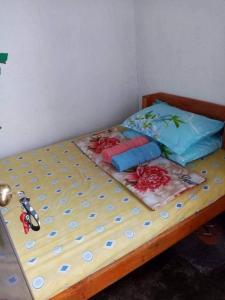 Una cama con dos almohadas encima en una habitación. en Yem Homestay, en Baguio