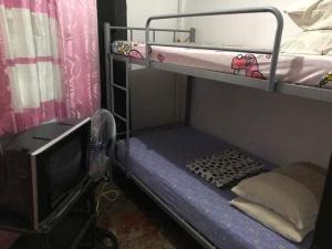 a small bunk bed with a tv and a bunk bed at Yem Homestay in Baguio