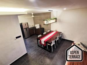 um quarto com uma mesa e uma cozinha com um frigorífico em Aspen Terrace - Classy Homestay 3 Rooms, 4 Baths em Sitiawan