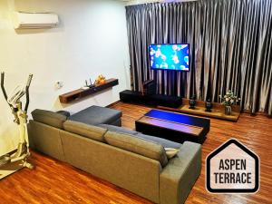 uma sala de estar com um sofá e uma televisão em Aspen Terrace - Classy Homestay 3 Rooms, 4 Baths em Sitiawan