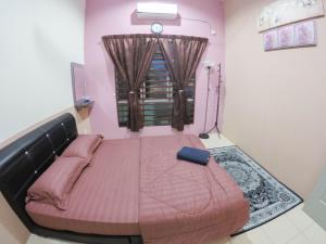 een slaapkamer met een groot roze bed en een raam bij D HOMESTAY SERI ISKANDAR in Seri Iskandar